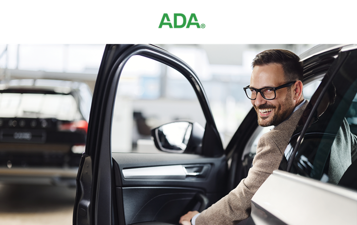 Man in glasses getting out of a car.