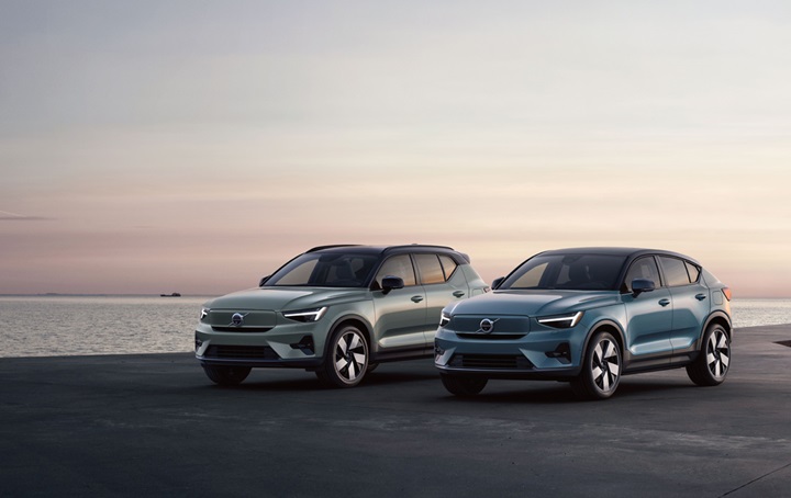 Two Volvo vehicles on a shoreline.