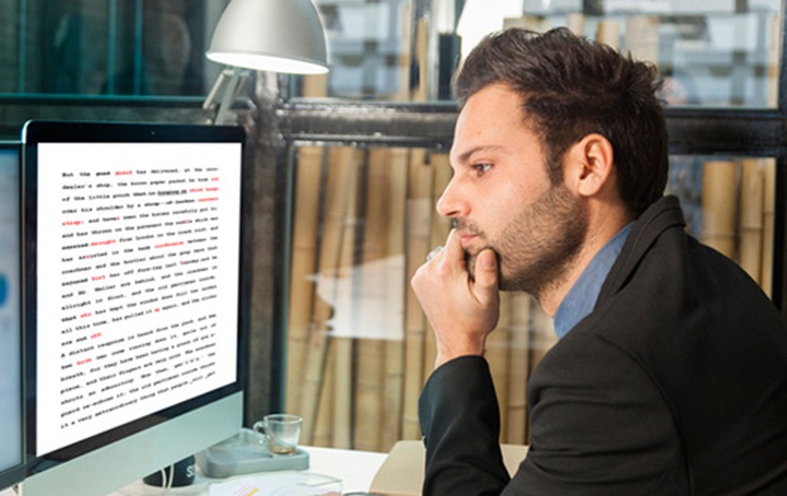 Man sitting at desk staring at computer screen and pondering.