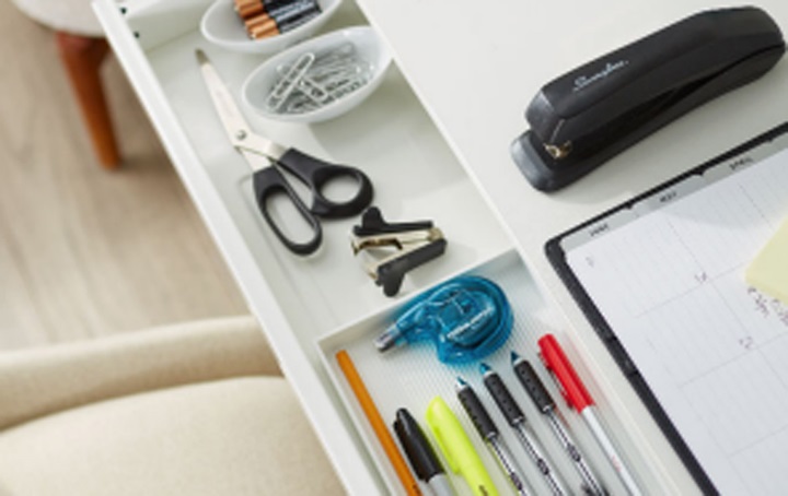 Desk with office supplies: pens, stapler, scissors, paper clips.